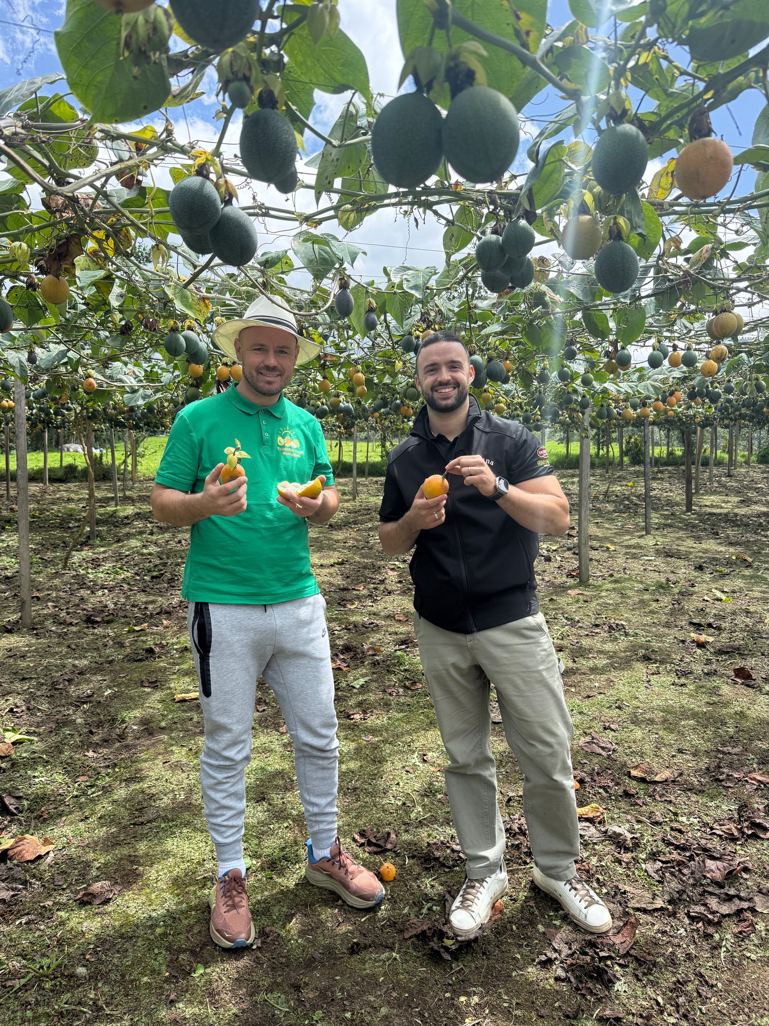 Marc Perals and Iulian Perseca hold granadillas in a granadilla farm
