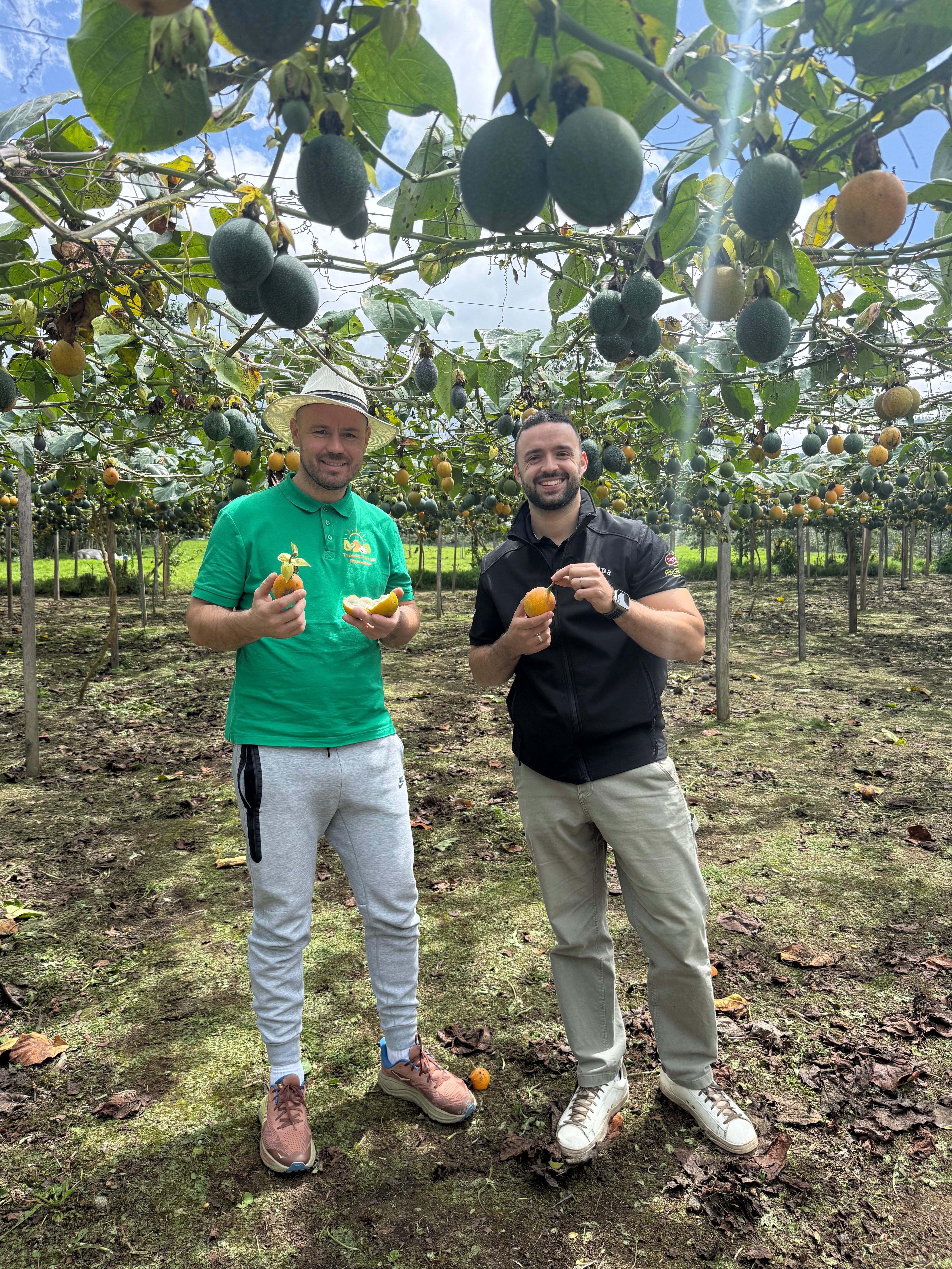Marc Perals and Iulian Perseca hold granadillas in a granadilla farm