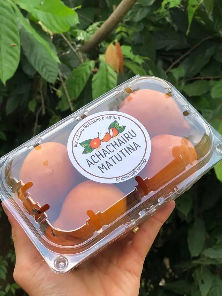 A premium clear plastic container of 'Achachairu Matutina' Boliviano fruits with a professional brand label.
