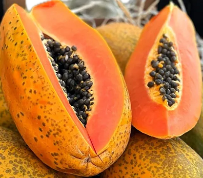Close-up of fresh organic bio papayas sliced open to reveal vibrant orange flesh and a center of black edible seeds.