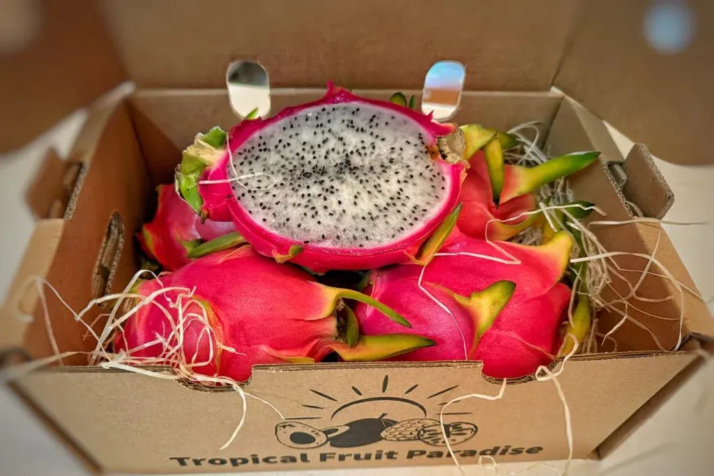 Fresh white dragon fruit (pitaya blanca) sliced in half to show the crisp white flesh with tiny black seeds and vibrant pink skin.
